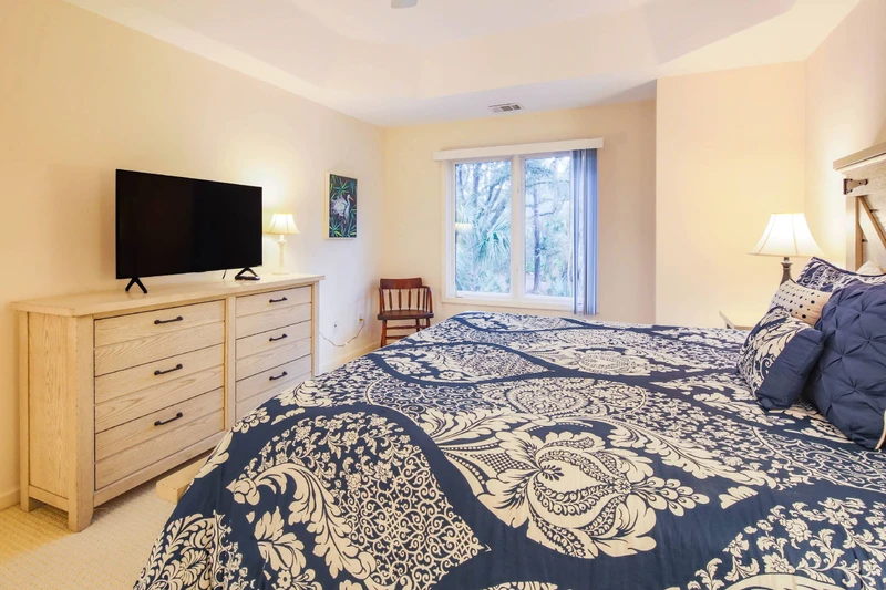 The king suite also features a dresser, smart TV and a chair.