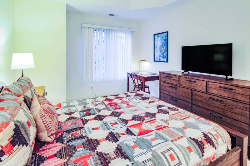 The queen suite also features a desk, dresser and smart TV.