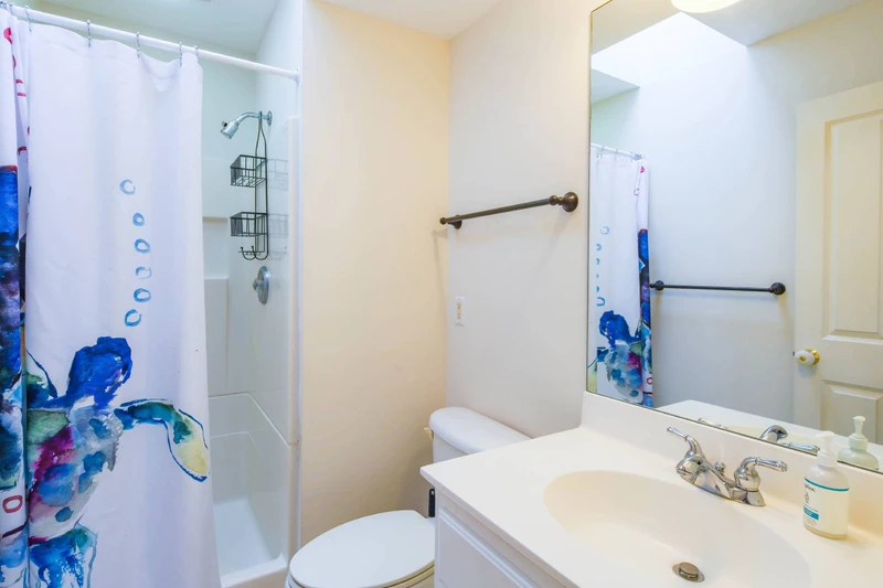 The en suite bathroom for the bunk bedroom features a vanity and a shower/tub combo.