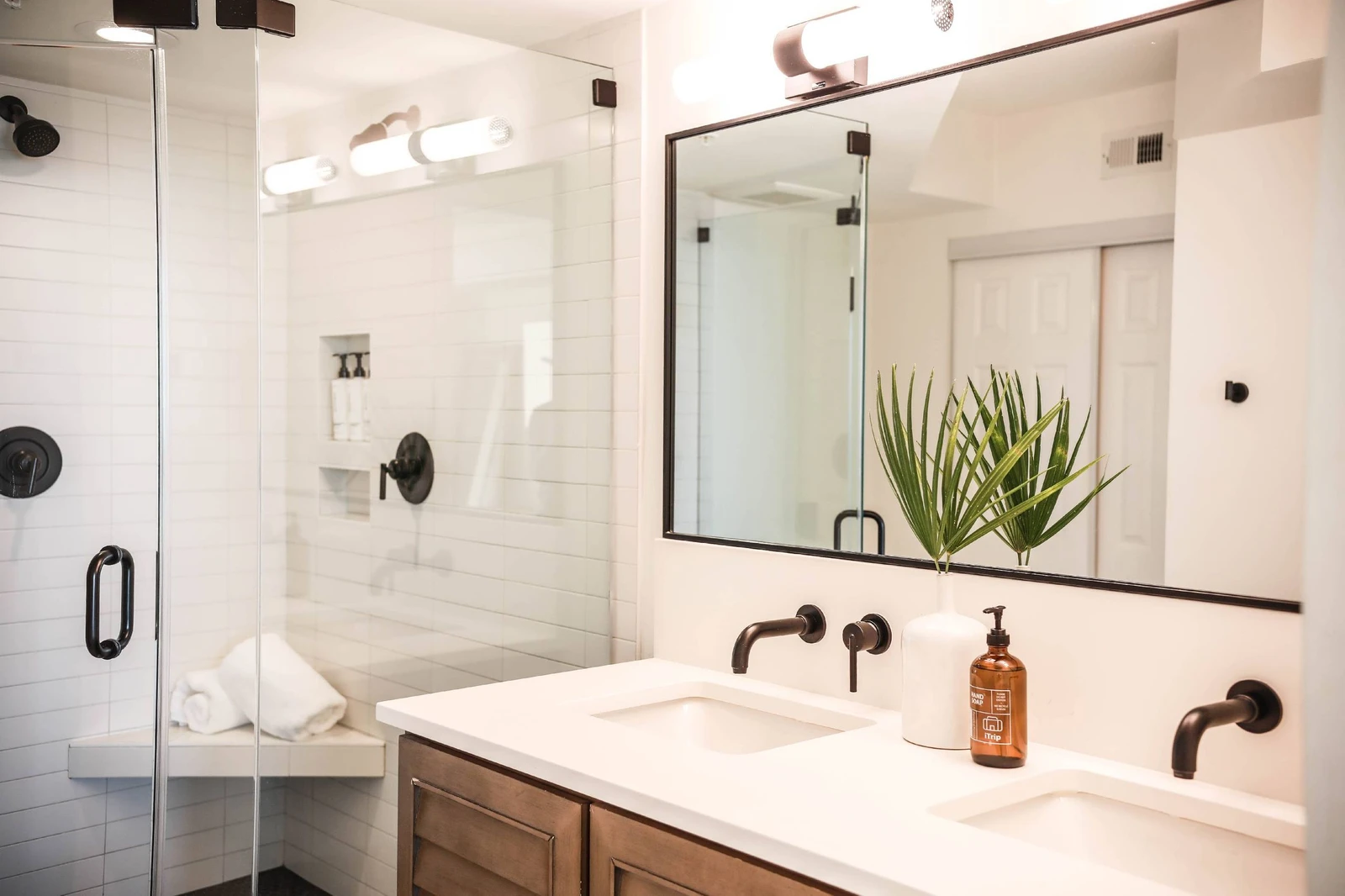 This primary bathroom features a spacious, tiled walk-in shower and a double sink vanity.