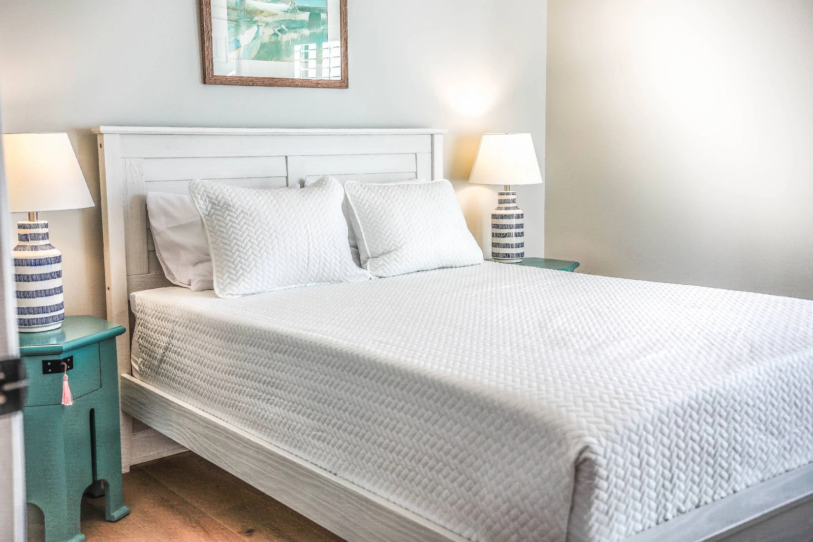 This guest bedroom features a queen bed, night stands with reading lamps and a ceiling fan.