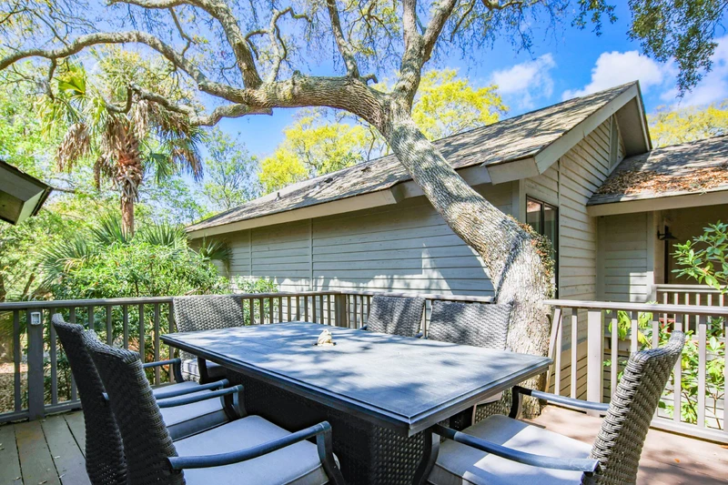 The shaded back deck features an outdoor dining table that seats 6.