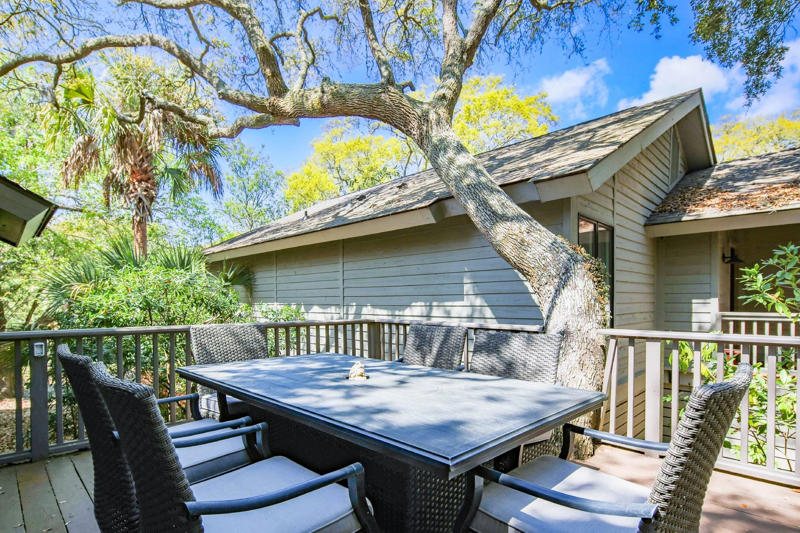 The shaded back deck features an outdoor dining table that seats 6.