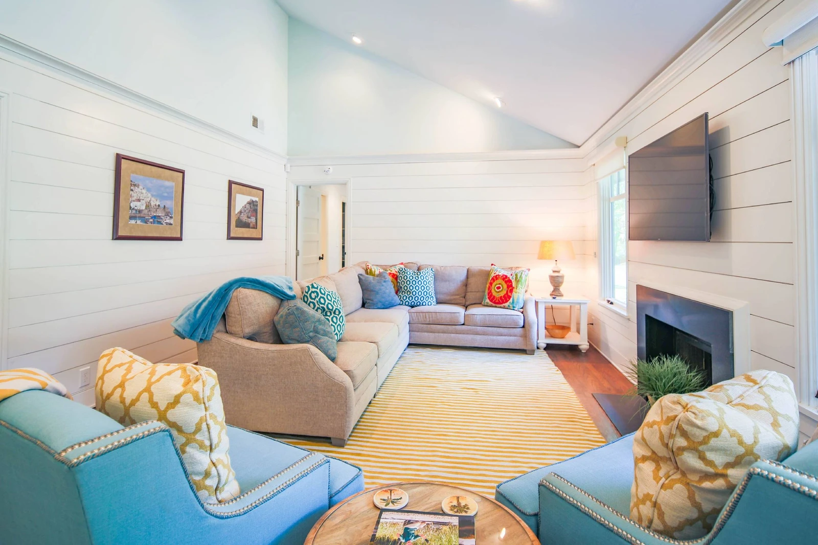 The living room features a spacious seating area with a large sectional and two arm chairs.