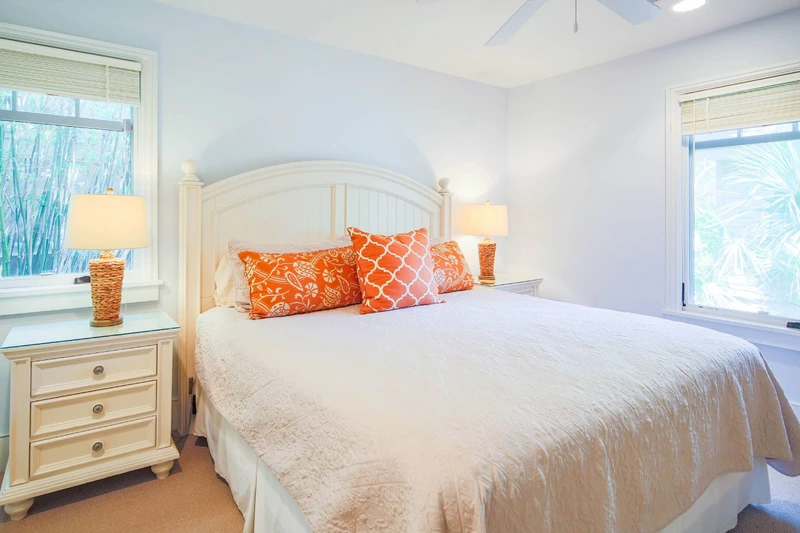 The primary suite features a king bed and night stands with reading lamps.