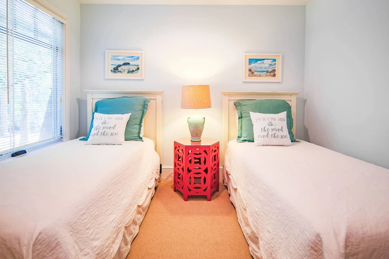 The twin bedroom features two twin beds and a night stand with a reading lamp.