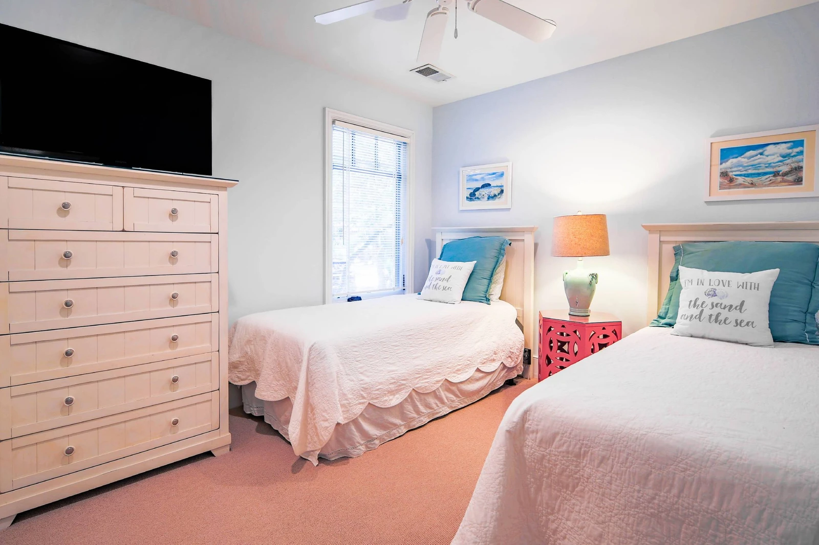 The twin bedroom also features a dresser, smart TV and ceiling fan.