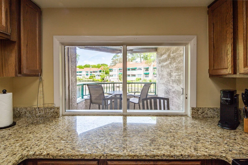 The kitchen looks out onto the covered balcony and lagoon.