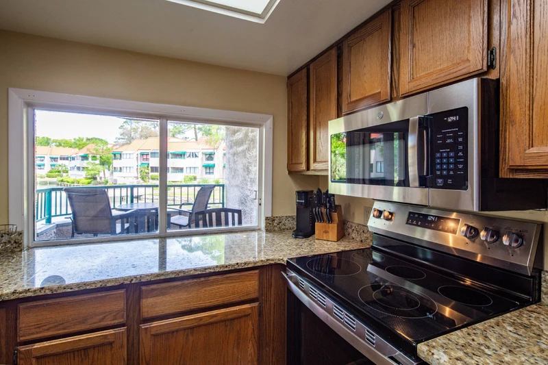 The kitchen features an electric range, microwave and keurig coffee maker.