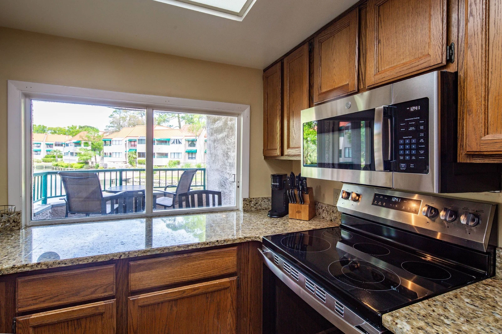 The kitchen features an electric range, microwave and keurig coffee maker.