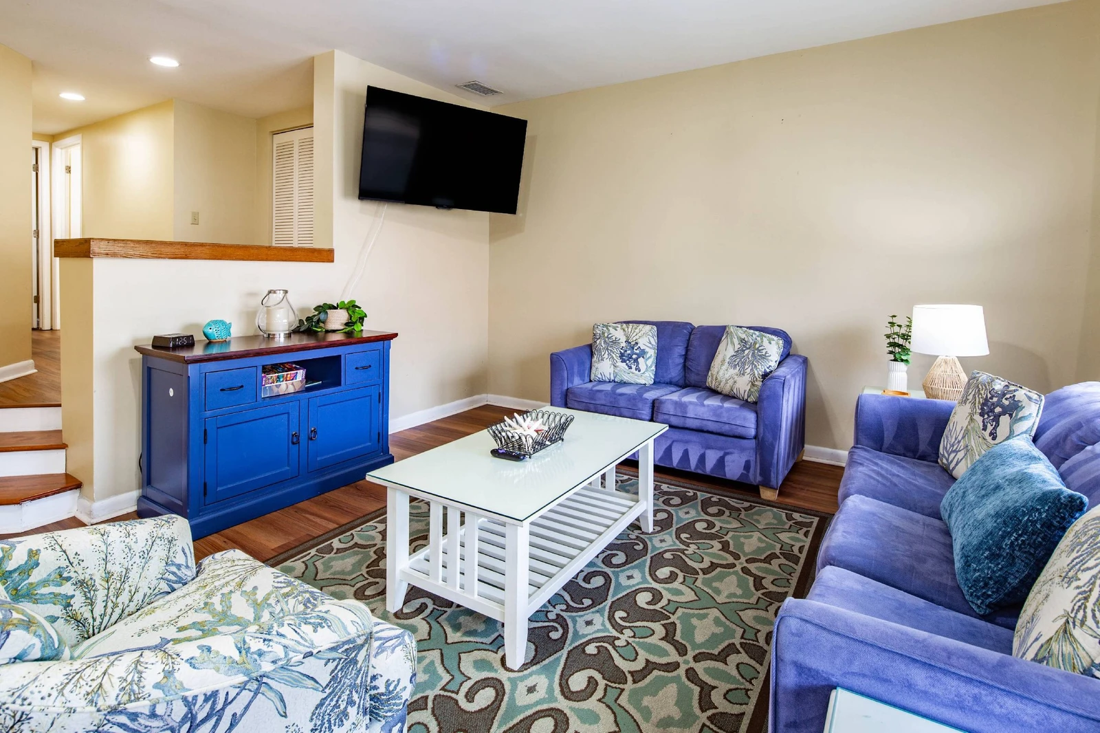 There is also a queen sleeper sofa and wall-mounted smart TV in the living room.