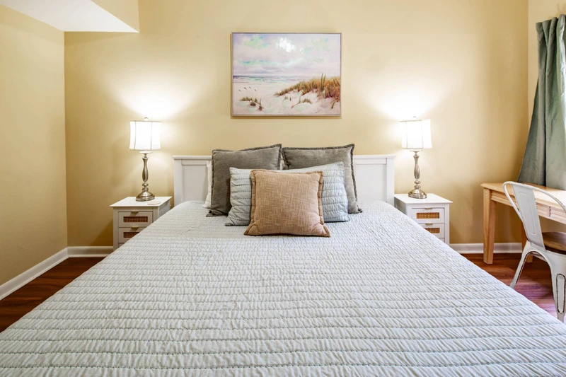 The primary bedroom features a queen bed and night stands with reading lamps.