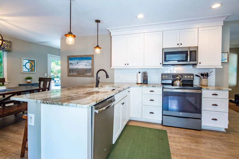 The kitchen opens onto the dining area, which then flows into the living room.