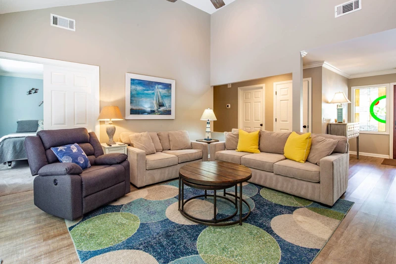 The king bedroom is adjacent to the living room and the primary suite & full suite are located down the hall from the living room.