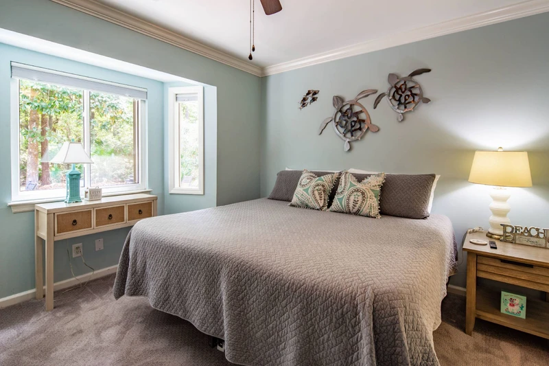 The king bedroom features a king bed, night stand with reading lamp and views of the back deck & patio.