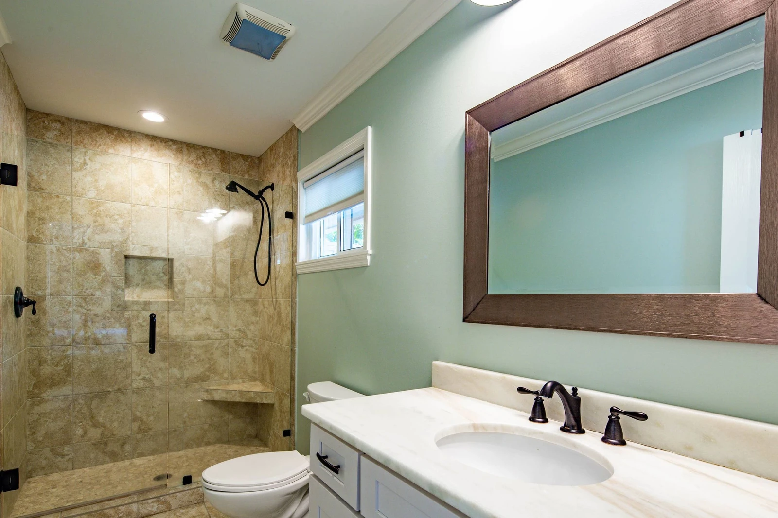 The en suite bathroom for the full suite features a vanity and tiled, walk-in shower.