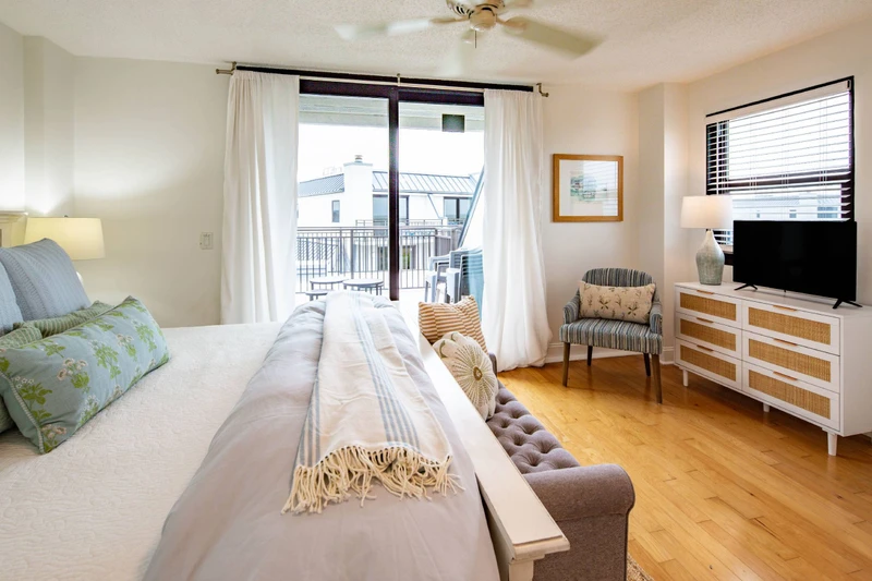 The guest suite also has a ceiling fan, arm chair, dresser and smart TV.