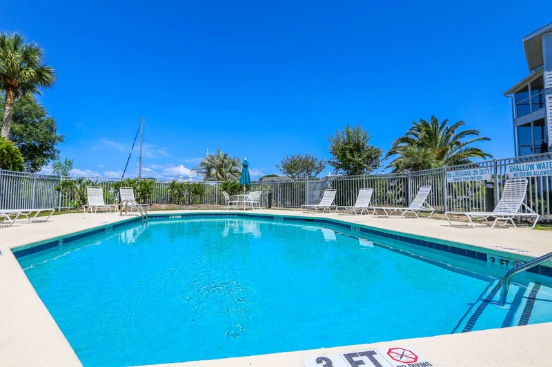 The community pool features a spacious sundeck with lounge chairs.
