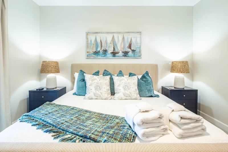 The primary suite features a king bed with night stands and reading lamps.