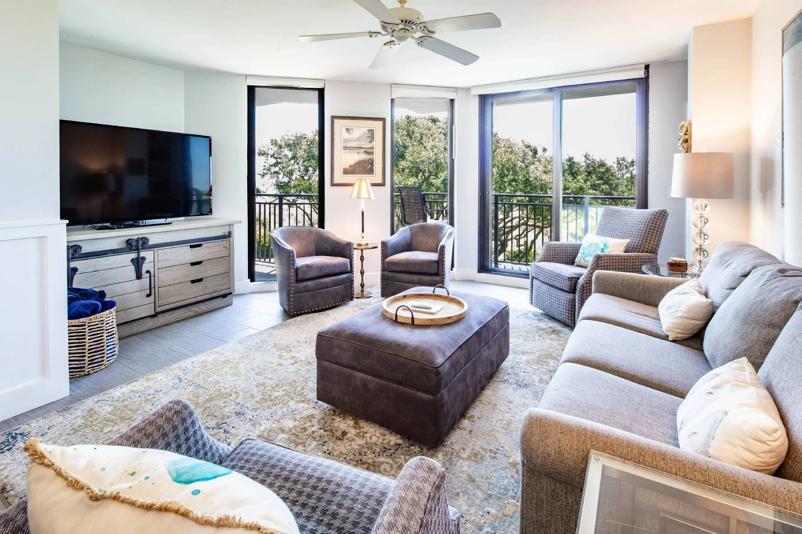 The living room features a spacious seating area, flat screen smart TV and access to the private balcony.