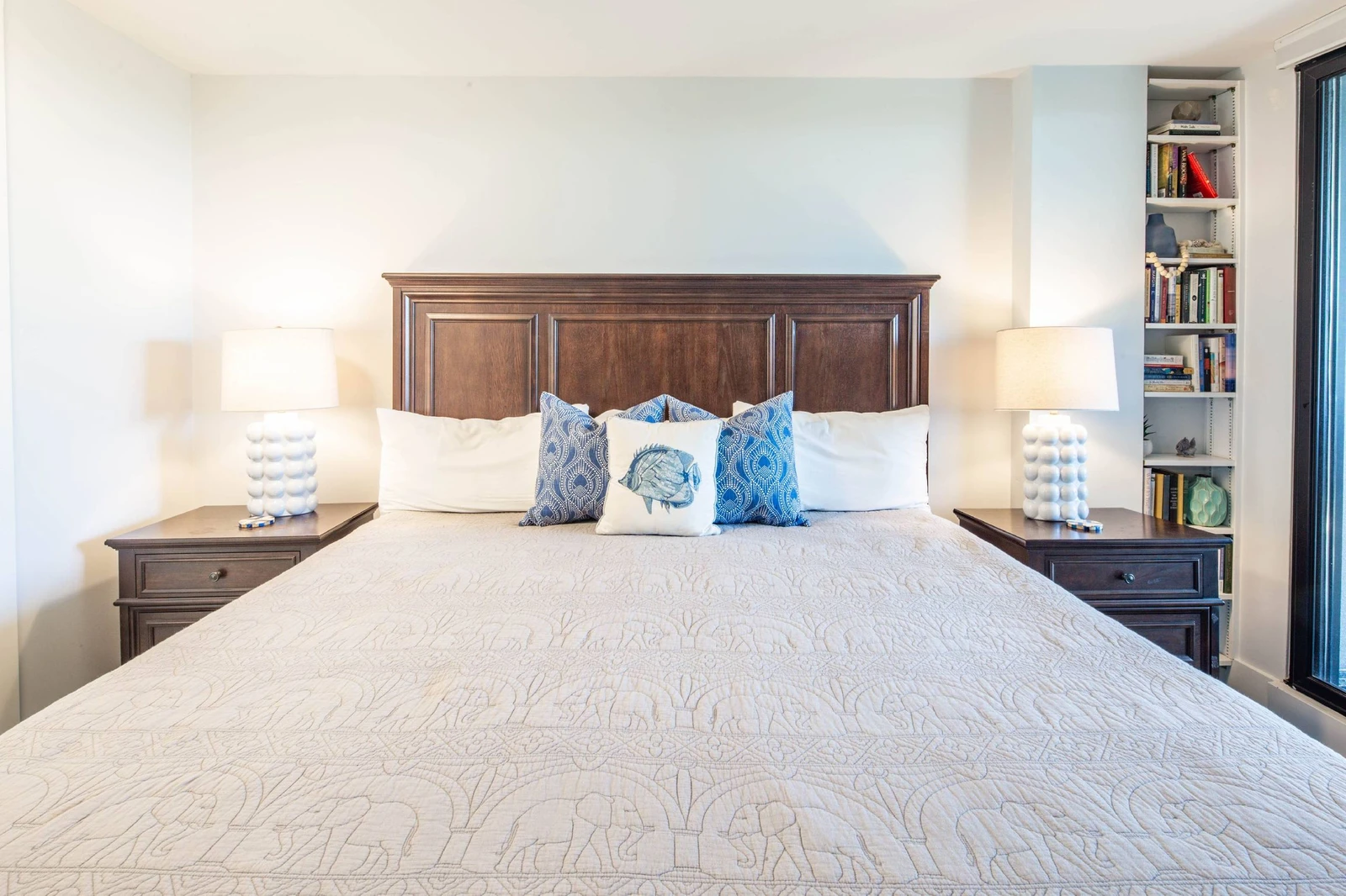 The primary suite features a king bed and night stands with reading lamps.