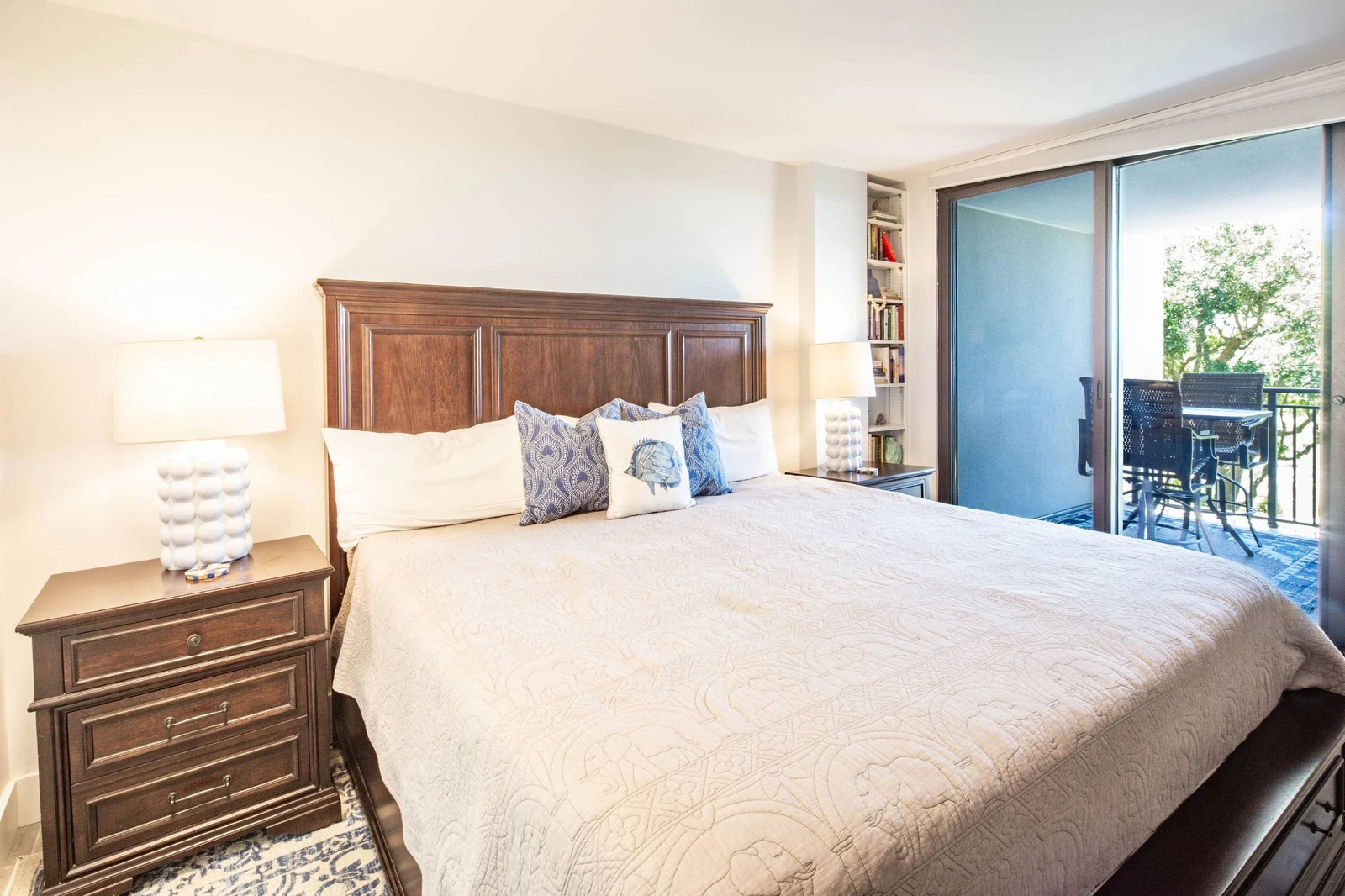 The primary suite features a sliding door access to the partially covered private balcony.
