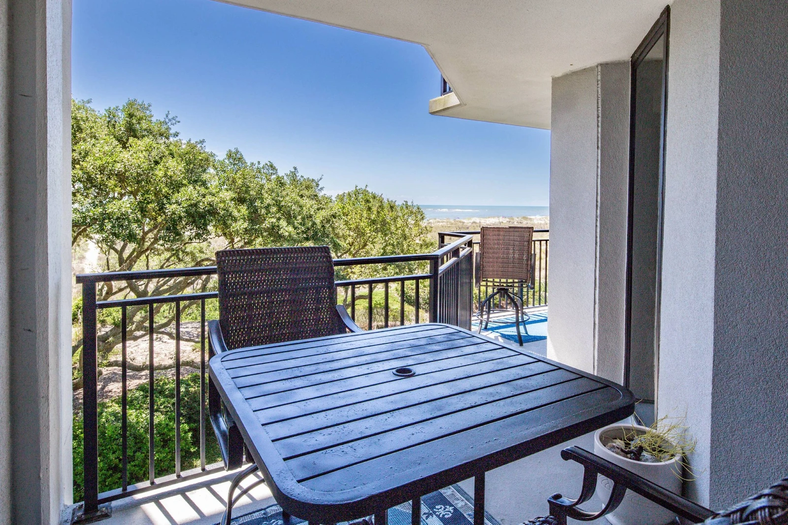 Step out onto the private balcony from the primary suite to find this high top table and chairs.