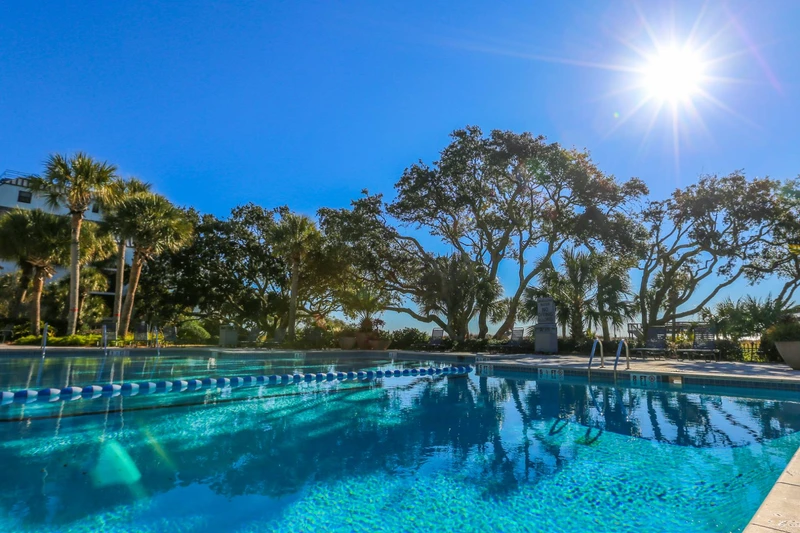 The Shipwatch community pool is lined with beautiful trees and landscaping.