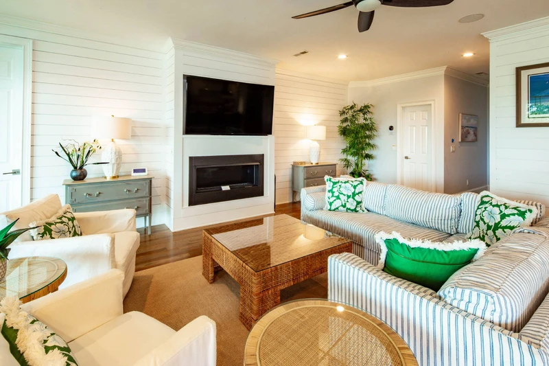 You'll find the living room with shiplap walls and mounted large screen TV on the second level of the home.