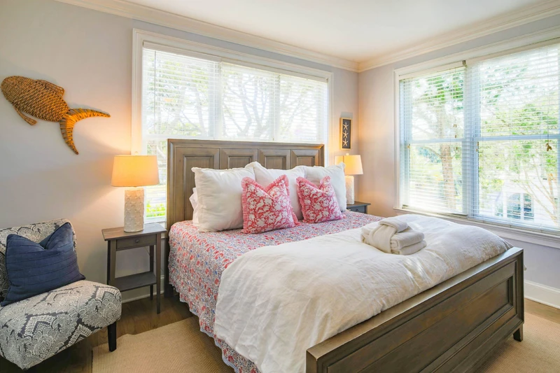 The lower level primary suite, which is located on the first floor, has a king bed and night stands with reading lamps.