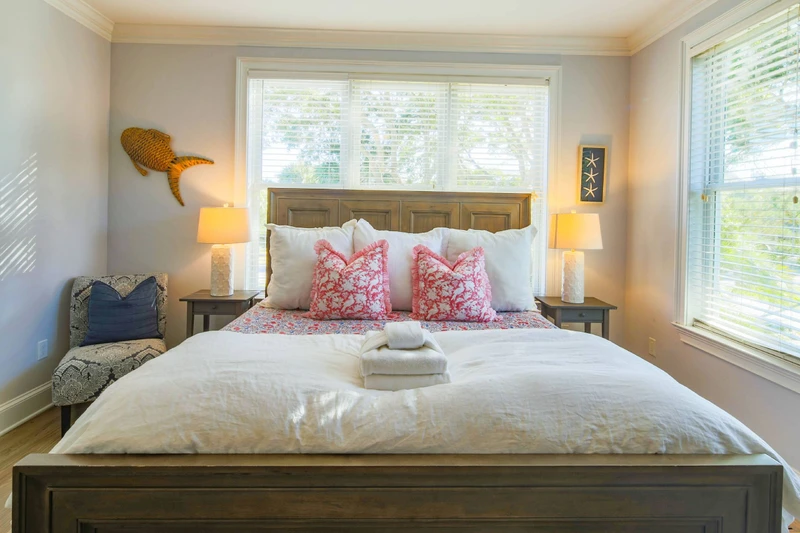 The lower level primary suite also has a chair and lovely natural light through the windows.