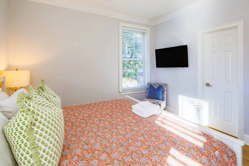 This king suite has a mounted, smart TV and access to a bathroom.