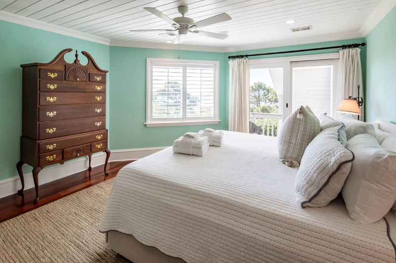 The primary suite, which is located on the upper level, features lovely natural light and ocean views.
