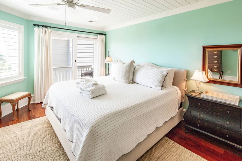 The primary suite features a king bed, night stands with reading lamps and access to a private balcony.