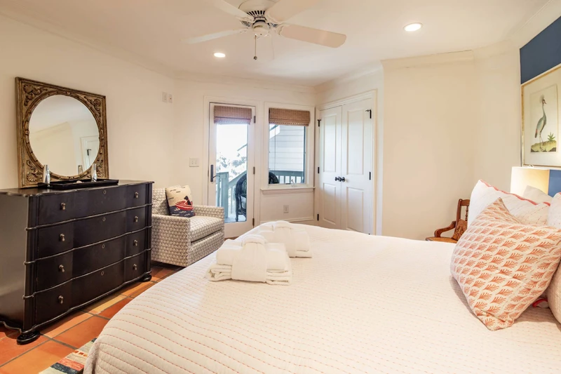 The queen suite also features a dresser, arm chair, ceiling fan and access to the screened porch.