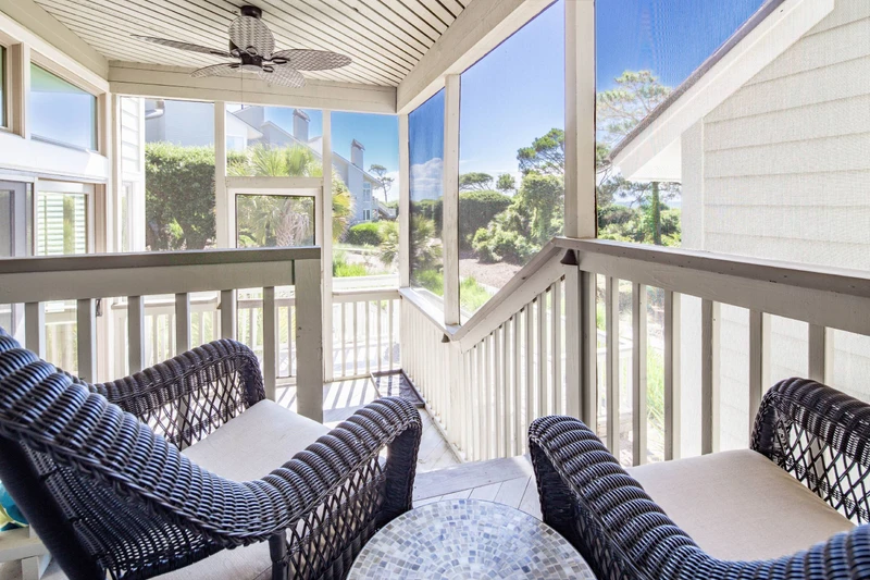 The screened porch has ocean views and steps down to the lower level off of the sunroom.