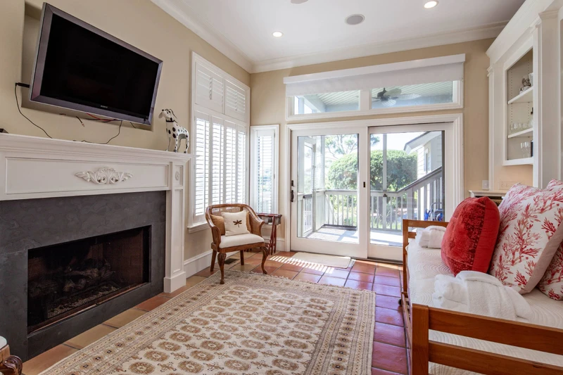 The sunroom also features a wall-mounted smart TV and sliding door access to the screened porch.